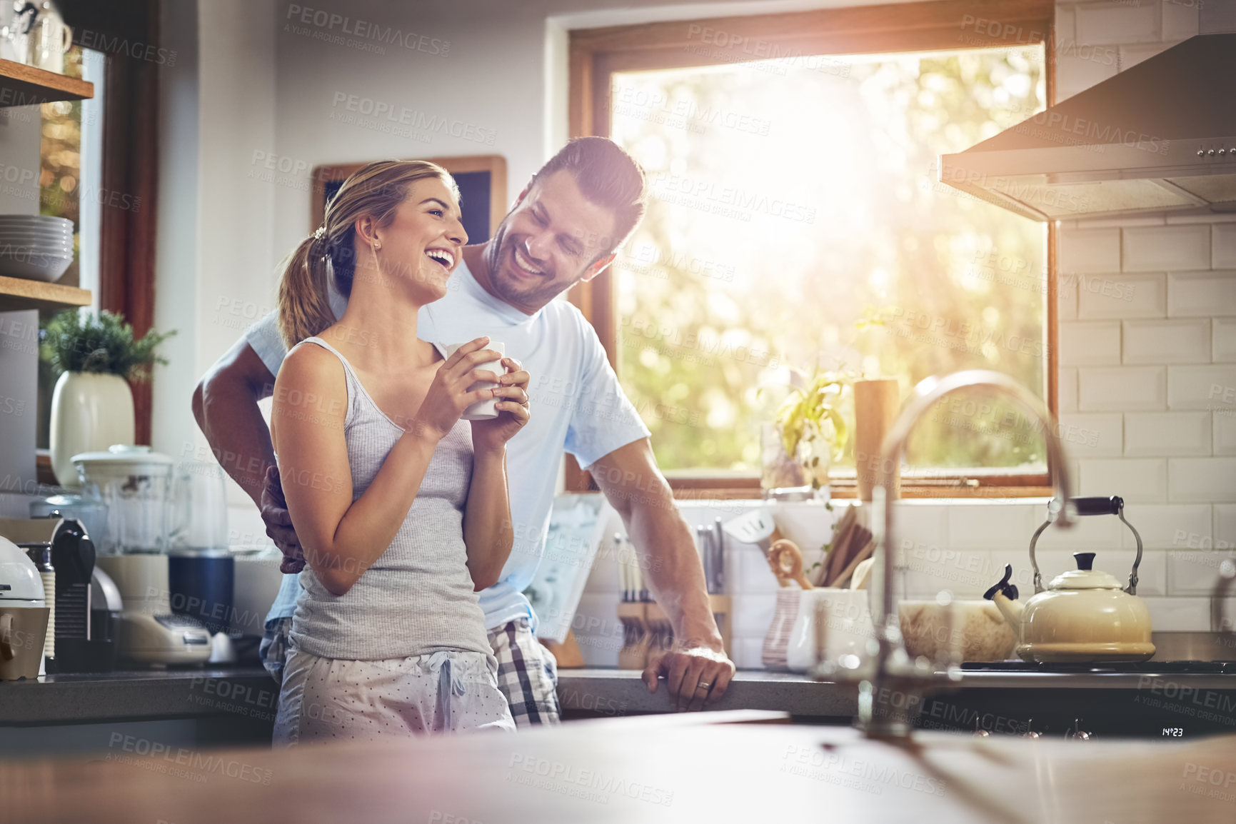 Buy stock photo Shot of a couple standing together in their kitchen