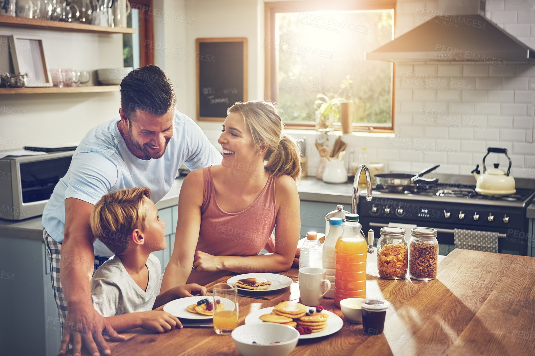 Buy stock photo Cropped shot of a little boy eating breakfast with his parents