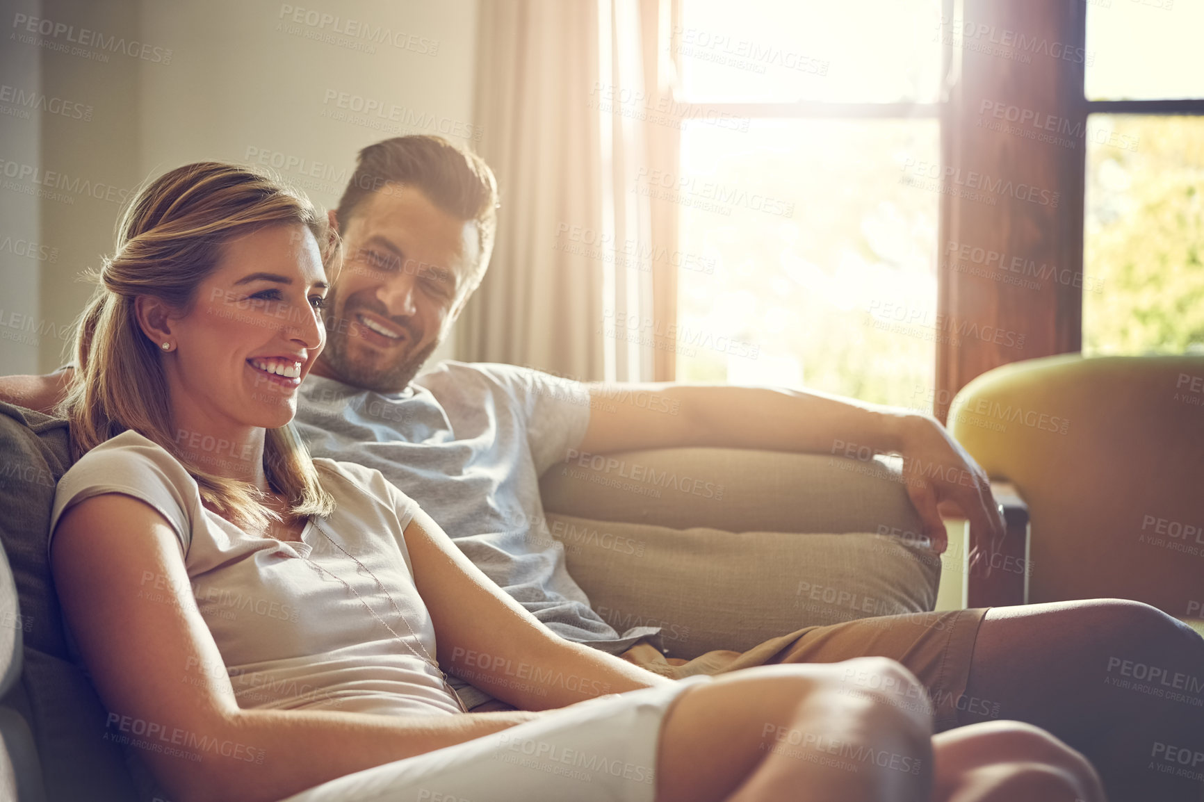 Buy stock photo Happy, home and couple with smile on sofa for support, comfort and bonding together on weekend. Man, woman and relax with love in living room for conversation, care and commitment in marriage