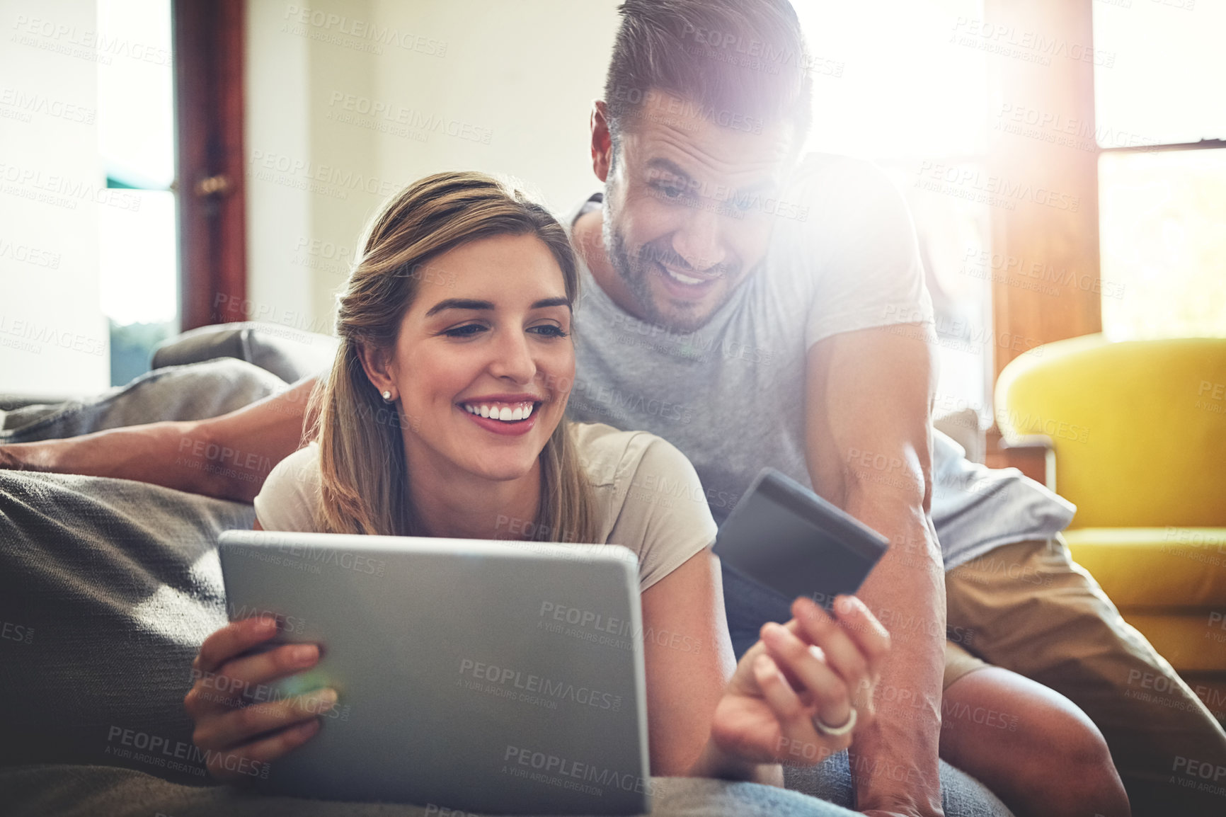 Buy stock photo Shot of an affectionate young couple relaxing on the sofa at home