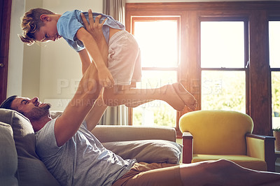 Buy stock photo Shot of a man spending some quality time with his son at home