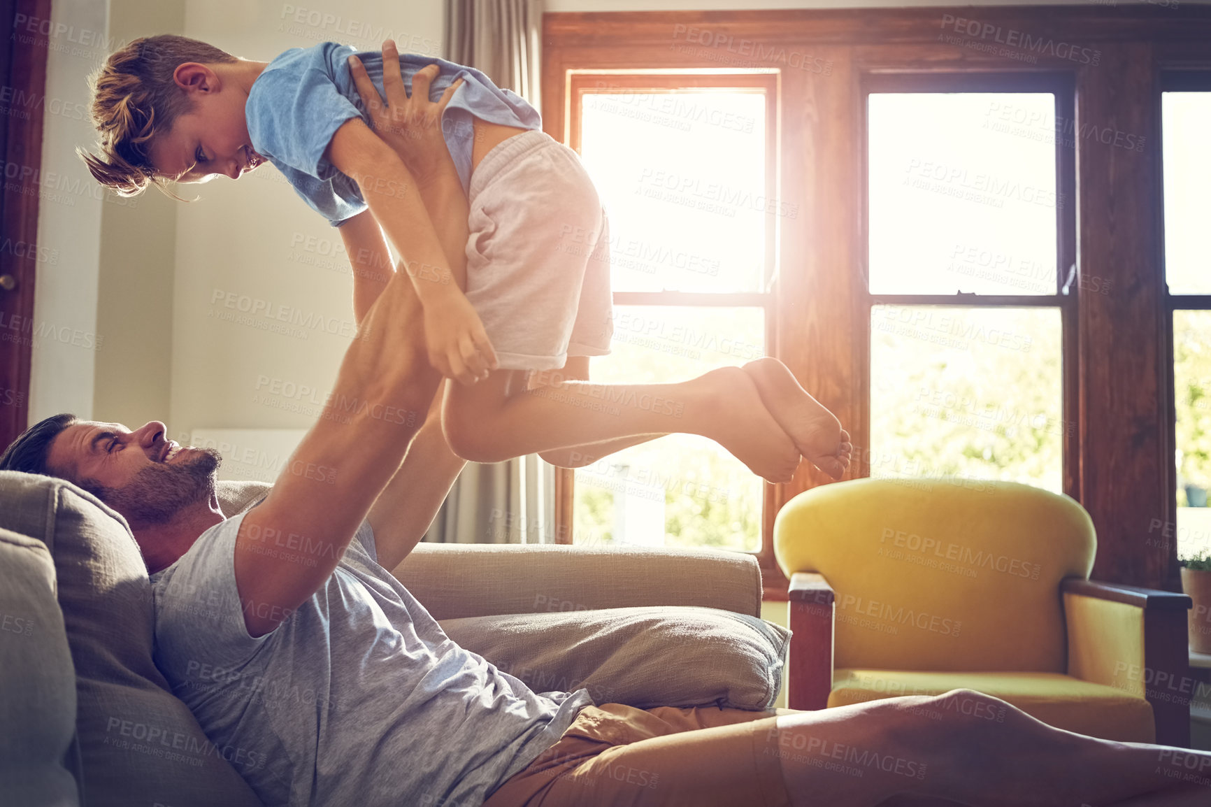 Buy stock photo Shot of a man spending some quality time with his son at home