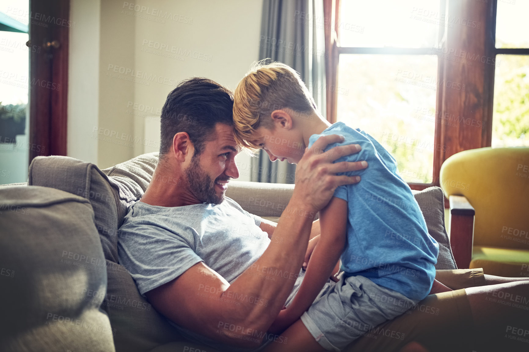 Buy stock photo Shot of a man spending some quality time with his son at home