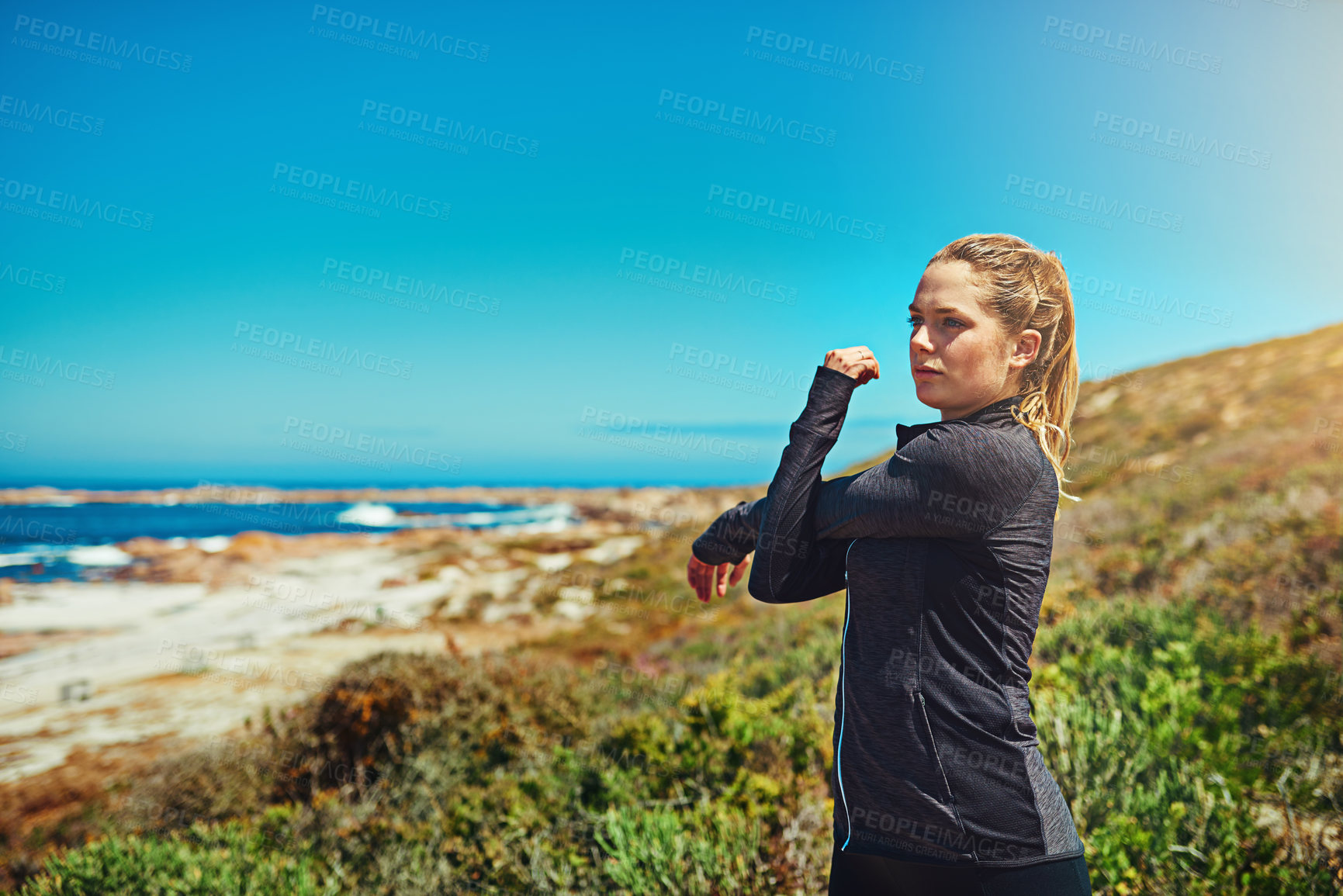 Buy stock photo Woman at beach, stretching arms with fitness and health, young athlete workout outdoor with focus and blue sky. Active female person in nature, warm up by ocean and exercise with mockup space