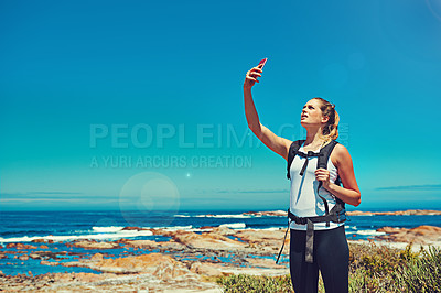 Buy stock photo Shot of a sporty young woman using her cellphone outdoors