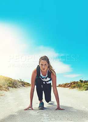 Buy stock photo Shot of a sporty young woman getting ready to run outdoors