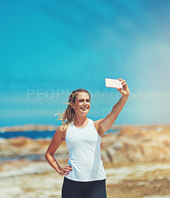 Buy stock photo Shot of a sporty young woman taking a selfie outdoors