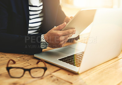 Buy stock photo Cropped shot of a businessman using a digital tablet and laptop at his work desk