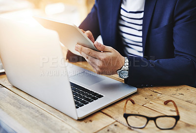 Buy stock photo Cropped shot of a businessman using a digital tablet and laptop at his work desk