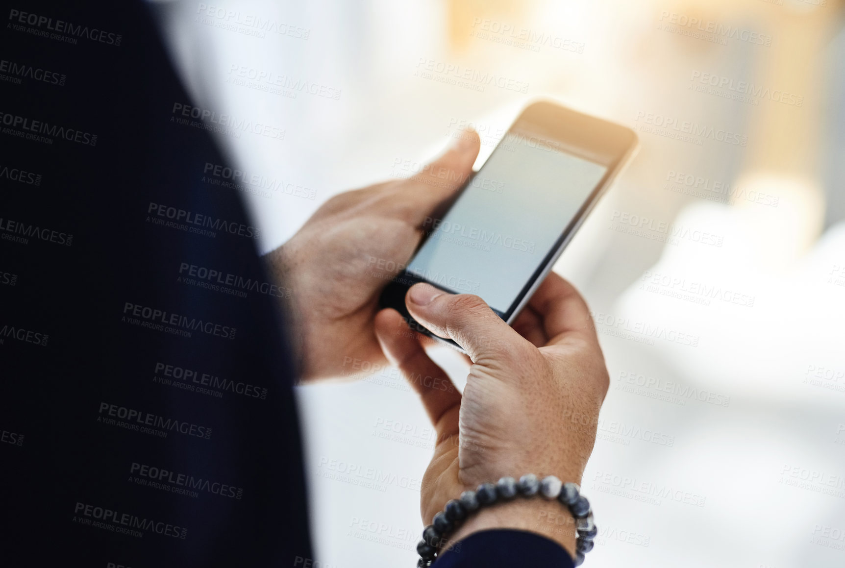 Buy stock photo Cropped shot of a businessman using a mobile phone in a modern office