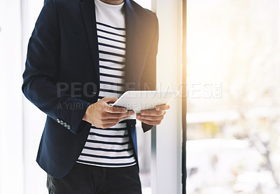 Buy stock photo Cropped shot of a businessman using a digital tablet in a modern office