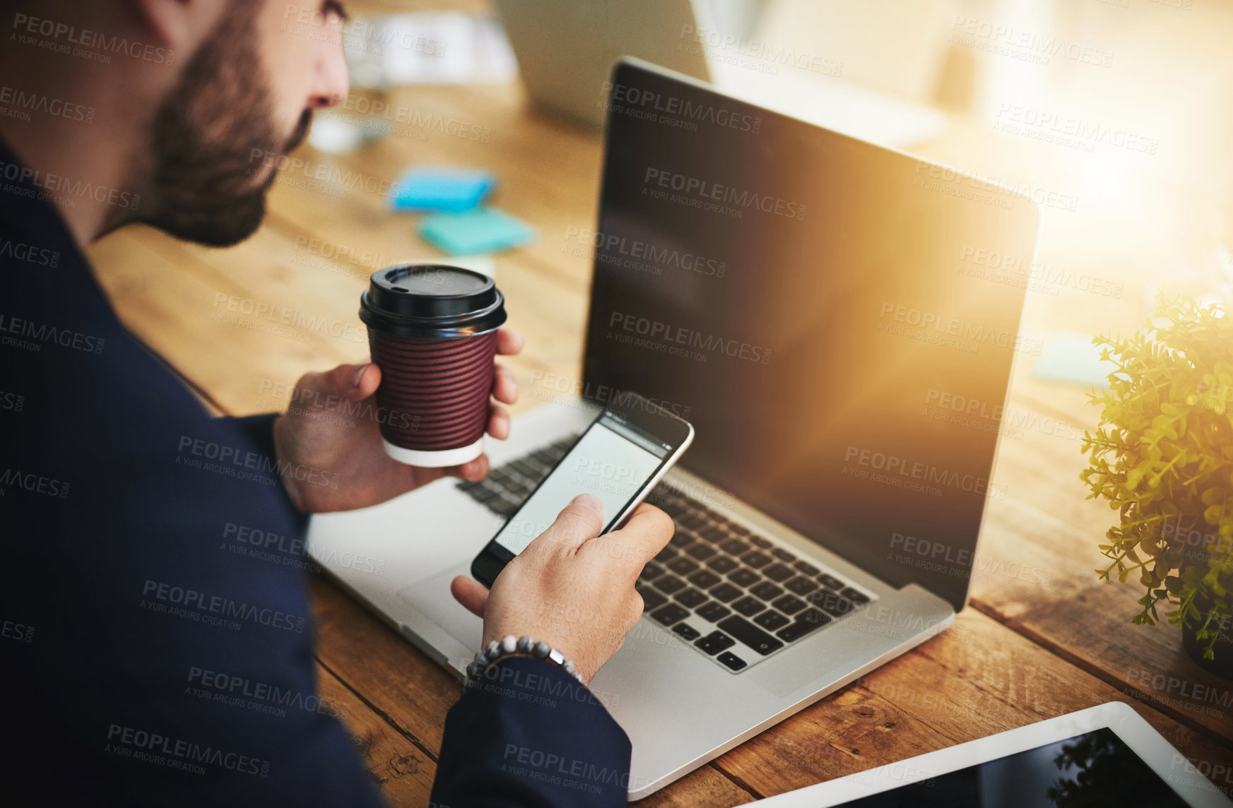 Buy stock photo Coffee, phone and laptop with man at coworking desk with blank screen for social media break on tech. Morning, web designer and creative job with latte and mobile scroll at office with design work