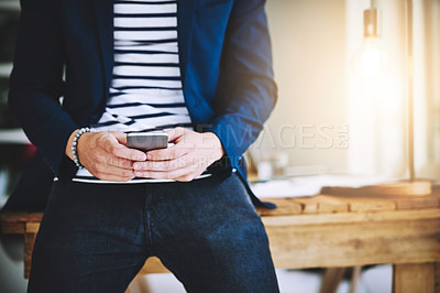 Buy stock photo Cropped shot of a businessman using a mobile phone in a modern office