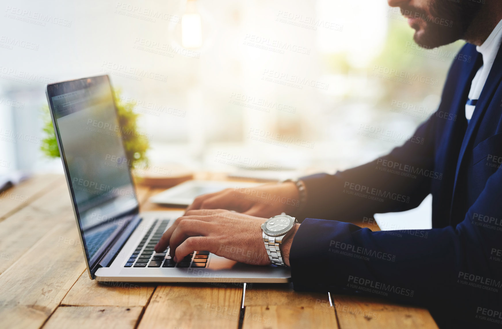 Buy stock photo Cropped shot of a businessman using a laptop at his work desk