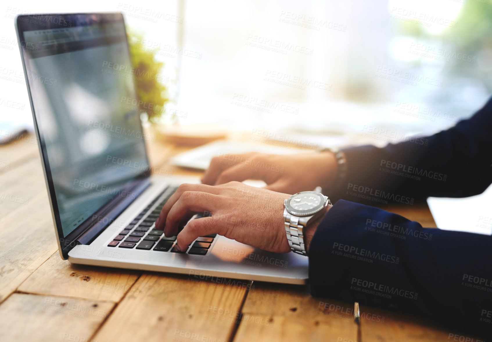 Buy stock photo Cropped shot of a businessman using a laptop at his work desk