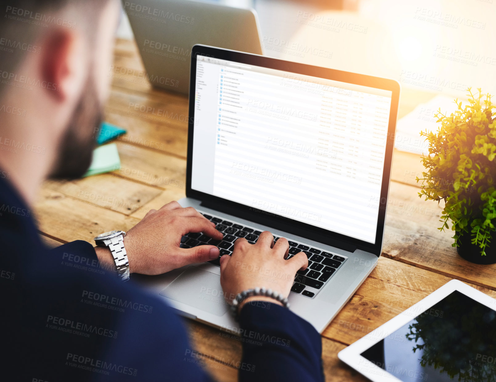 Buy stock photo Cropped shot of a businessman using a laptop at his work desk