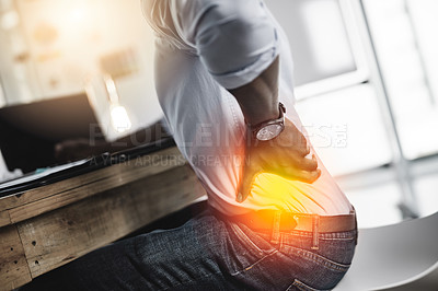 Buy stock photo Shot of a unrecognizable businessman suffering from back pains while trying to work in the office