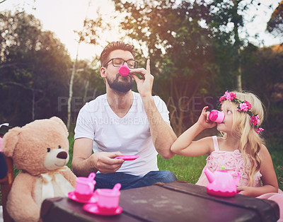 Buy stock photo Shot of a cheerful daughter and father having a tea party with a bunch of stuffed toys in the middle of a garden