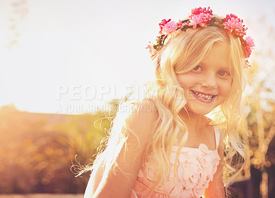 Buy stock photo Shot of a happy little girl looking at the camera while standing in the sun outside in nature