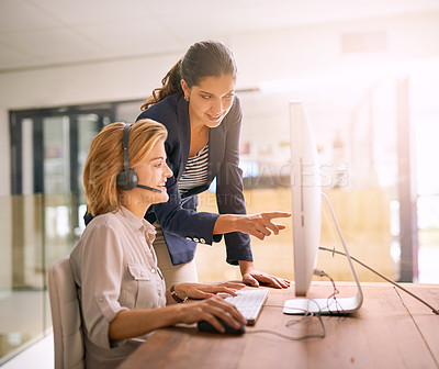 Buy stock photo Cropped shot of a young woman helping a colleague while working in a call center