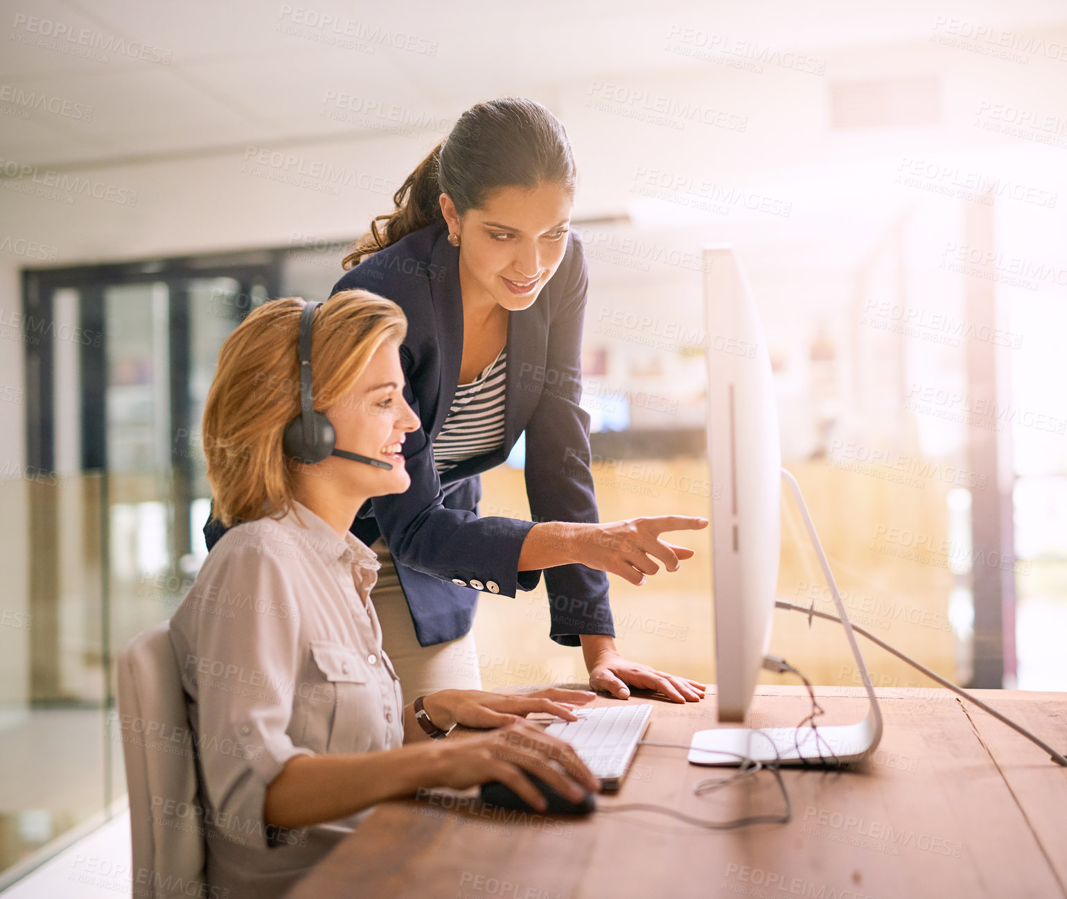 Buy stock photo Cropped shot of a young woman helping a colleague while working in a call center