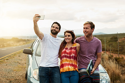 Buy stock photo Shot of a group young friends getting in close or a self portrait photo while standing next to a road