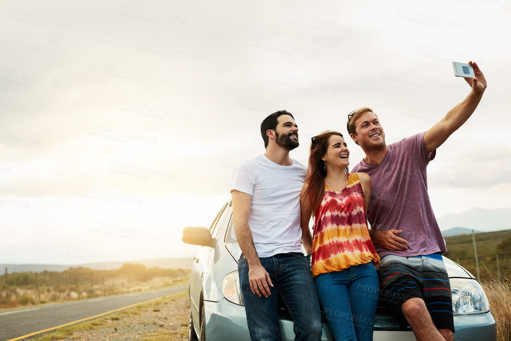 Buy stock photo Shot of a group young friends getting in close or a self portrait photo while standing next to a road