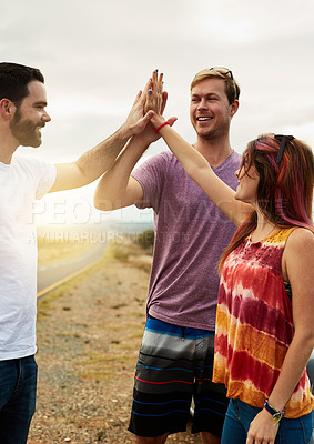 Buy stock photo Shot of a group young friends engaging in a high five outside next to a road