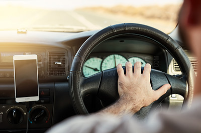 Buy stock photo Shot of a unrecognizable man driving and hooting in a vehicle with his cellphone attached to the dashboard