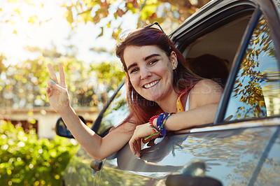 Buy stock photo Shot of a young woman showing a peace sign and looking at the camera while sitting in the backseat of a car