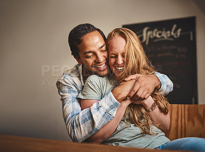 Buy stock photo Happy couple, hug and smile for romance, embrace or relationship happiness at indoor restaurant. Young man hugging woman and smiling for fun love or dinner date spending bonding time at cafe together