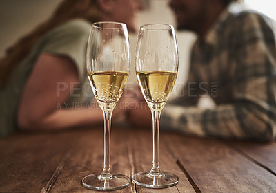 Buy stock photo Champagne, glass and love on valentines day with a couple kissing in the background of a restaurant for romance. Alcohol, drink or dating with a man and woman sharing a kiss on a romantic date
