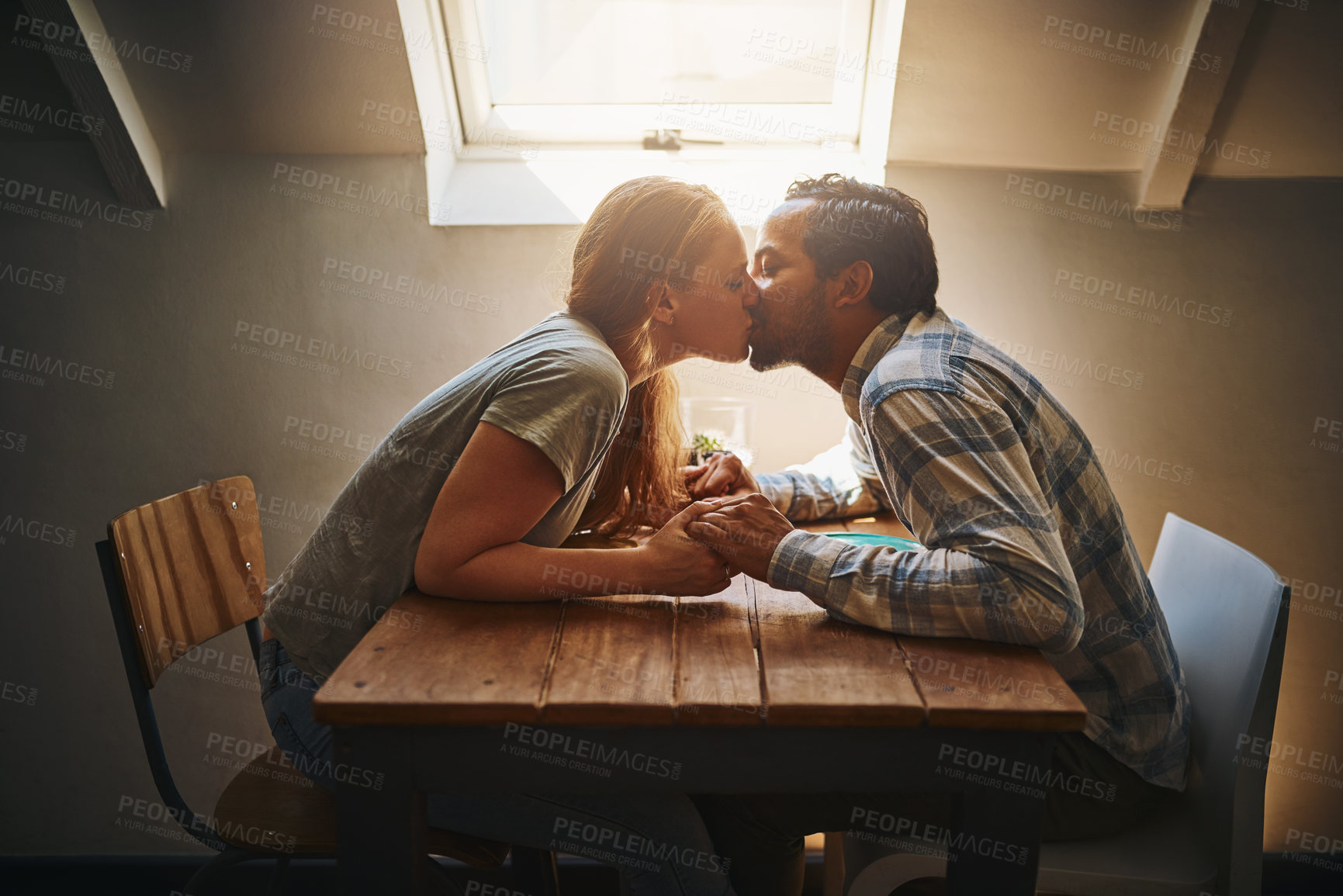 Buy stock photo Kiss, couple love and holding hands at cafe on table, passion or bonding together. Valentines day, romance diversity and affection of man and woman on date, kissing and enjoying time in restaurant.