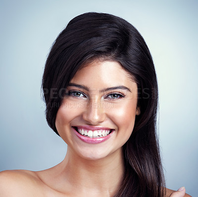 Buy stock photo Studio shot of a beautiful young woman posing against a blue background