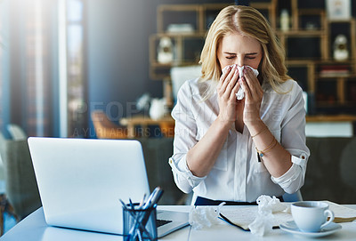 Buy stock photo Shot of a frustrated businesswoman using a tissue to sneeze in while being seated in the office