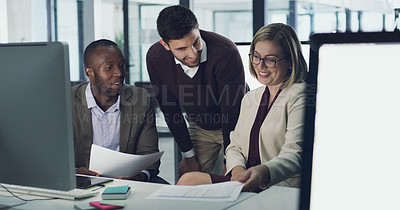 Buy stock photo Cropped shot of three businesspeople discussing some paperwork in their office