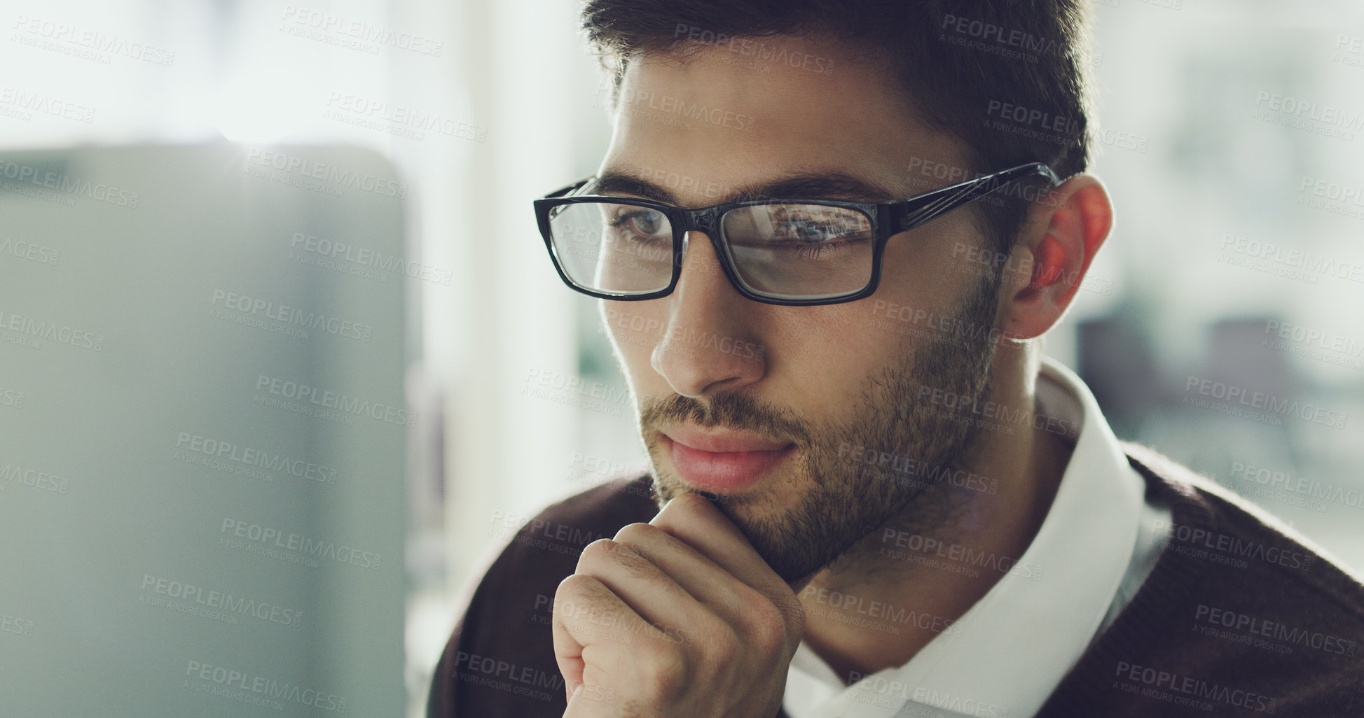 Buy stock photo Cropped shot of a handsome young businessman working on his computer in the office