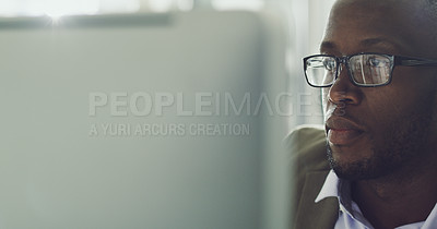 Buy stock photo Cropped shot of a handsome young businessman working on his computer in the office