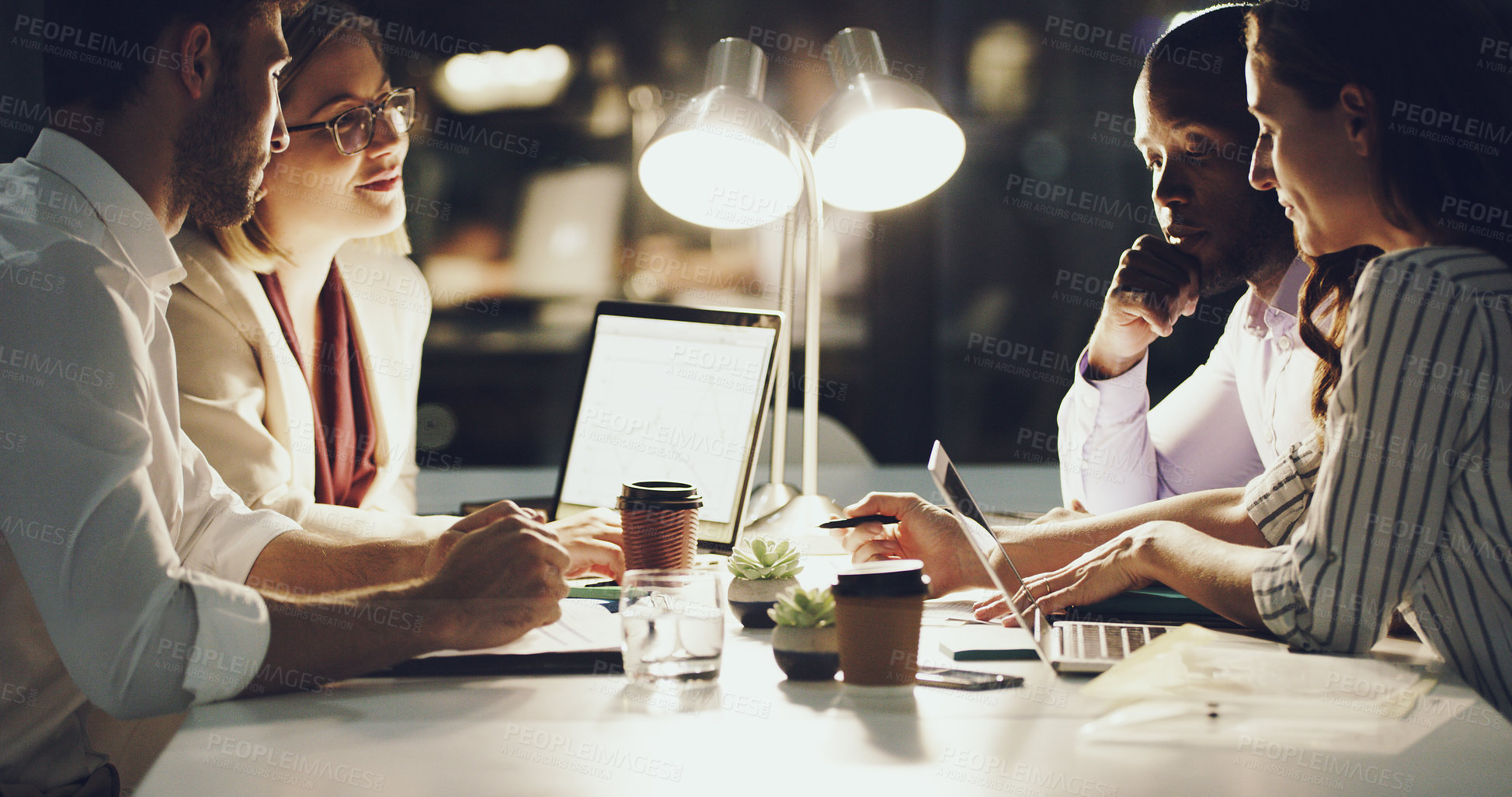 Buy stock photo Cropped shot of a group of businesspeople working around a table in the office