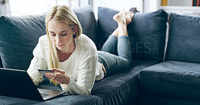Buy stock photo Full length shot of an attractive young woman using her laptop to do some online shopping at home