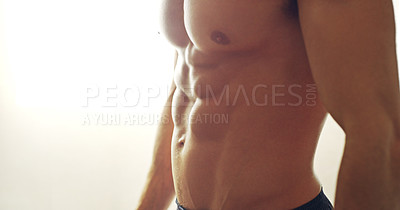 Buy stock photo Cropped shot of a muscular man standing shirtless in his home
