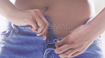 Buy stock photo Cropped shot of an unrecognizable young woman unbuttoning her jeans