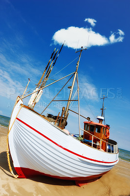 Buy stock photo Beautiful landscape of a white fishing boat parked at the beach on a sunny day. Fishing boat on a sandy beach. A local fishing boat moored at the shore on a beautiful bright  wooden boat on the beach