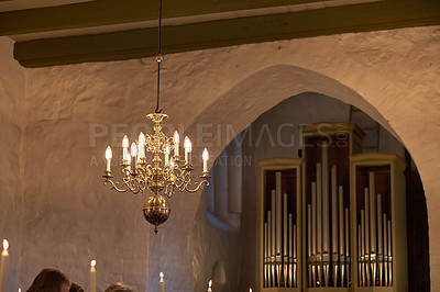 Buy stock photo Old fashioned brass chandelier with candle light bulbs hanging from roof or ceiling in a historic building and vintage room. Shiny ornamental, medieval, ancient and antique light fixture in a mansion