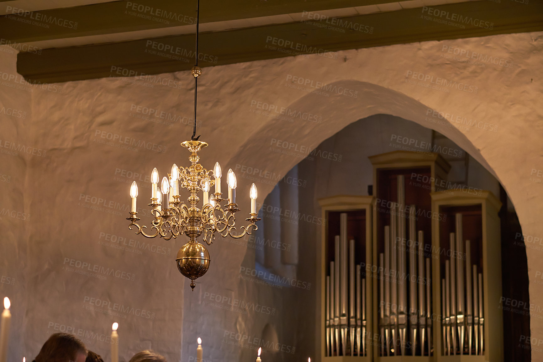 Buy stock photo Old fashioned brass chandelier with candle light bulbs hanging from roof or ceiling in a historic building and vintage room. Shiny ornamental, medieval, ancient and antique light fixture in a mansion