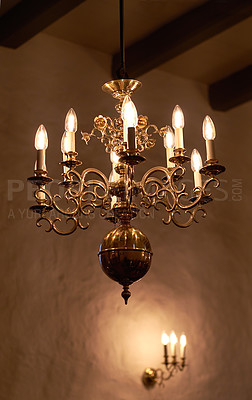 Buy stock photo Antique brass chandelier with candle light bulbs hanging from roof or ceiling in a historic,midieval building and vintage room. Shiny ornamental, old fashioned and ancient light fixture in a mansion