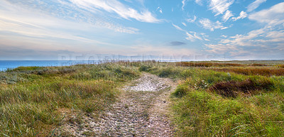 Buy stock photo Grass field, banner and blue sky with clouds or path for nature trail, scenery or travel in countryside. Landscape, natural growth or ocean view with greenery or terrain for eco friendly environment