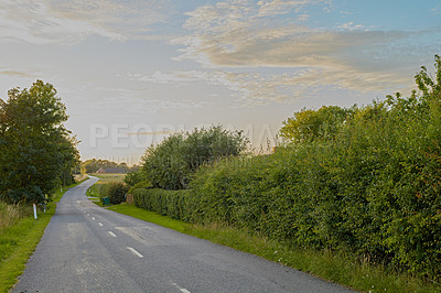 Buy stock photo Road, forest and trees in countryside with clouds, path and sky in horizon for journey on land. Woods, nature and highway outdoor for travel, holiday and vacation destination for tourism in Denmark