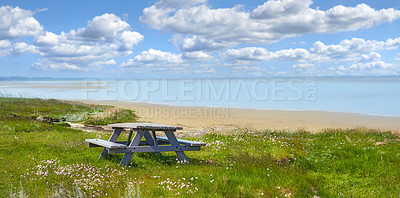 Buy stock photo Nature, grass and beach with bench outdoor of flower growth, ocean landscape and tropical travel. Green, plants and scenic coastline for garden seat, blue sky and sea water for destination in Denmark