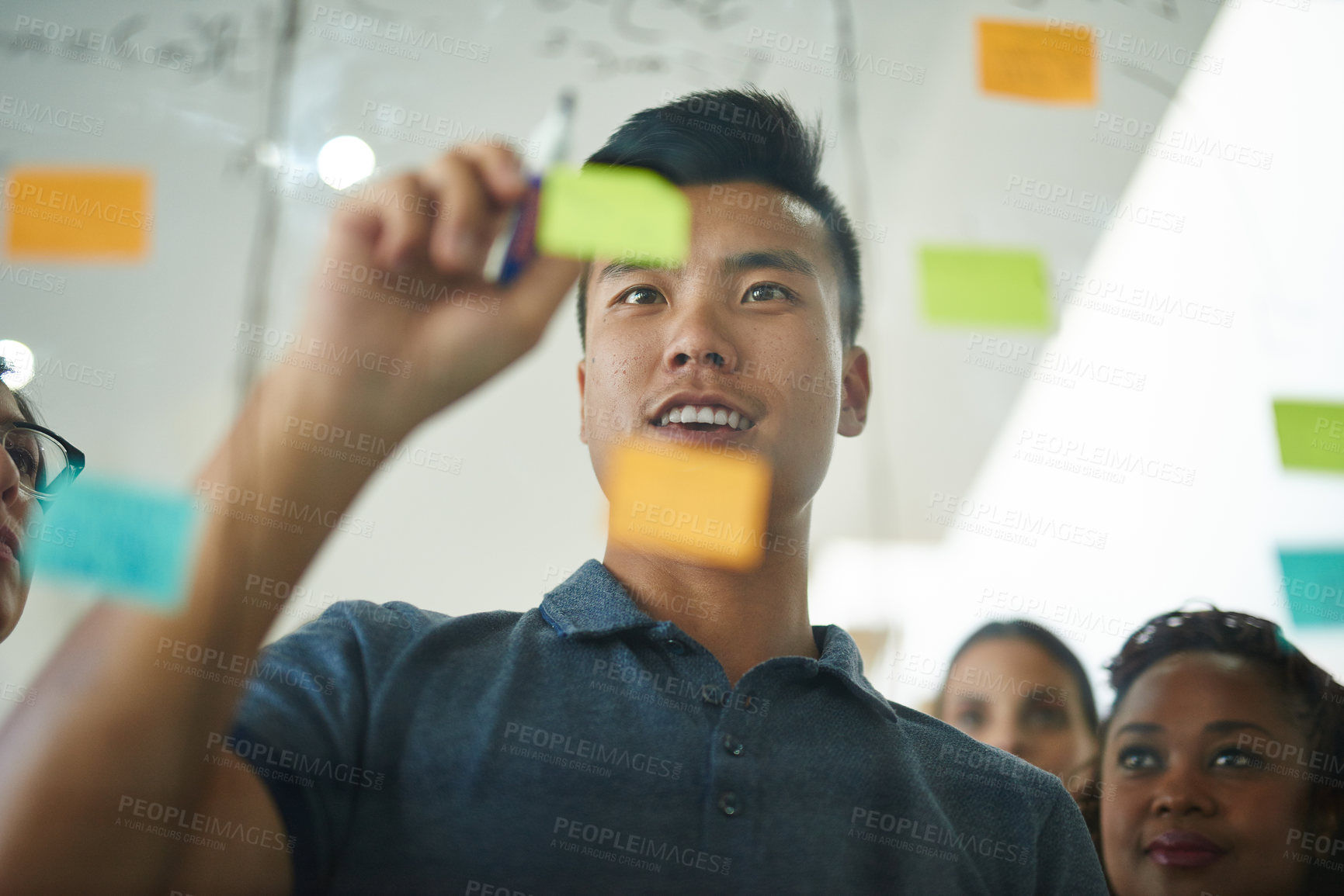 Buy stock photo Cropped shot of a group of young designers planning on a glass board